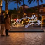 Santa and flying reindeer light sculpture in a resort courtyard
