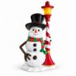 6 foot snowman in a black top hat and red and green striped scarf leaning on a lit red and white candy stripe lamppost
