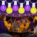 Purple and Yellow LED filament G40 globe string lights glowing over an outdoor game day gathering