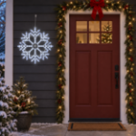 24" Fancy LED Snowflake Pure White lit and mounted beside a front door on a snowy evening