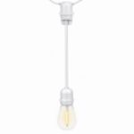 White socket extender hanging from a patio string light with a lit bulb