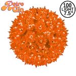 Lit orange RetroGlo starlight sphere, 7.5 inch, shown against white