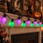 Purple and green RetroGlo C9 Halloween lights glowing in a decorated Halloween scene